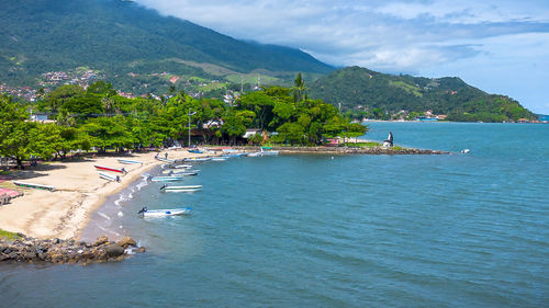 Scenic view of sea and mountains against sky