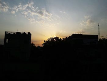 Silhouette buildings against sky during sunset