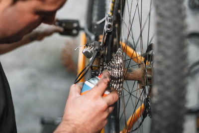 Cropped image of man repairing bicycle at workshop