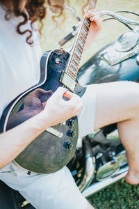 Midsection of man playing guitar