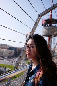 Portrait of beautiful young woman in city against sky