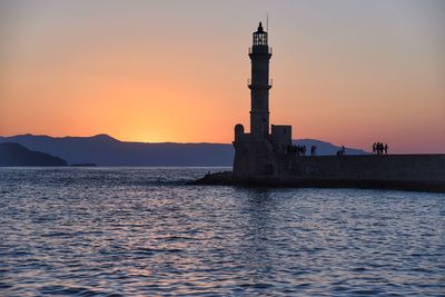 Lighthouse at seaside during sunset