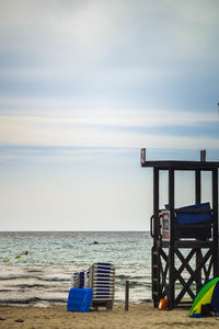 Lifeguard hut on beach against sky and horizon 