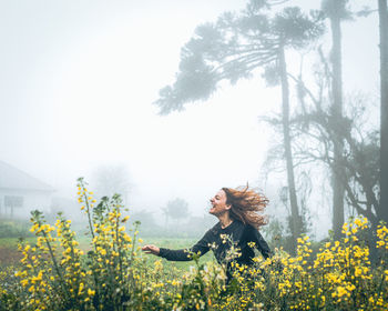 Young woman with yellow flowers on field