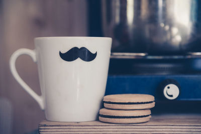 Close-up of coffee cup and cookies on table