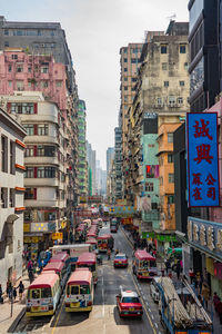 Vehicles on road amidst building in city