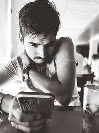 Portrait of man holding drink at restaurant