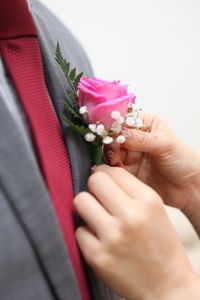 Close-up of woman putting flower in pocket