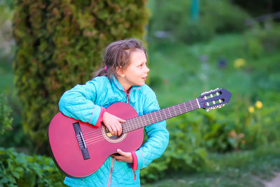 Full length of a woman playing guitar