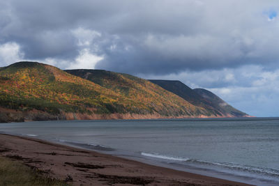 Scenic view of sea and mountains against sky