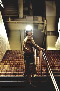 Woman walking on staircase of building