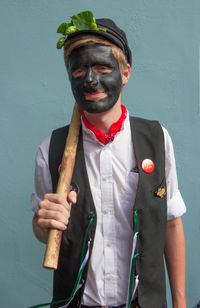 Portrait of man standing against wall