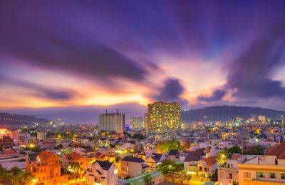 High angle view of illuminated buildings against sky at sunset