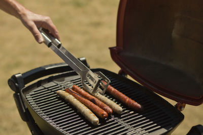Close-up of hand on barbecue grill