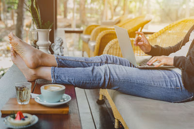 Midsection of woman holding coffee cup on table