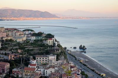 High angle view of townscape by sea against sky