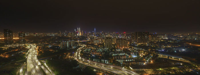 High angle view of illuminated cityscape against sky at night