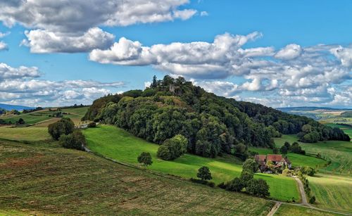 Scenic view of agricultural landscape against cloudy sky