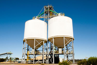 Low angle view of crane against clear blue sky