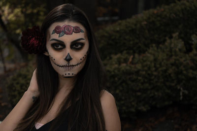 Close-up of thoughtful woman with spooky halloween make-up against plants