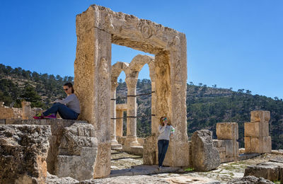 Friends by old ruins against mountain