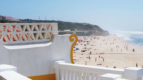 People at beach against clear sky during summer