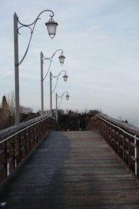 Footbridge over street against sky