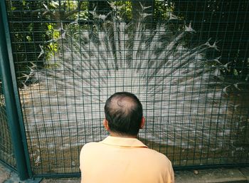 Rear view of man standing against brick wall