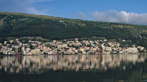 Scenic view of townscape by mountains against sky