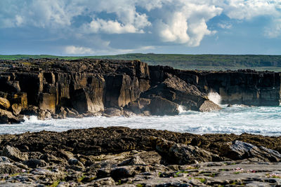 Scenic view of rocky beach against sky