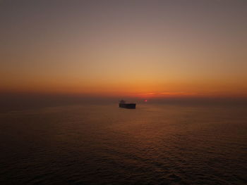 Scenic view of sea against orange sky