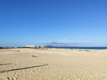 Scenic view of beach against clear blue sky