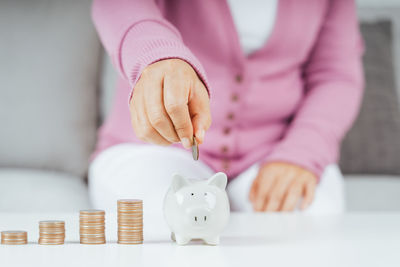 Close-up of hand holding coins on table