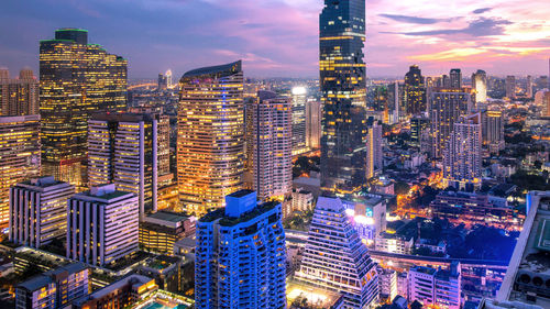 Aerial view of illuminated buildings in city against sky