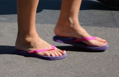 Low section of woman wearing flip-flops