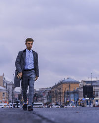 Man standing in city against sky