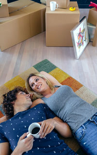 High angle view of couple sitting on sofa at home