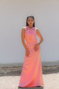 Portrait of young woman standing on pink land