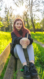 Portrait of young woman sitting on field