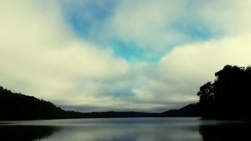 Scenic view of calm lake against cloudy sky