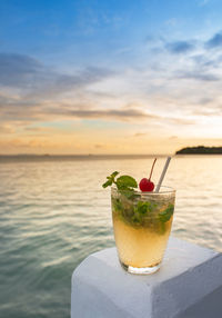 Close-up of drink on table against sky during sunset