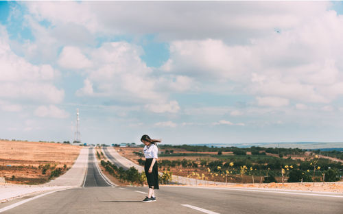 Rear view of woman on road against sky