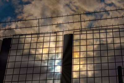 Low angle view of sky seen through metal fence