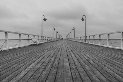 Surface level of footbridge over footpath against sky