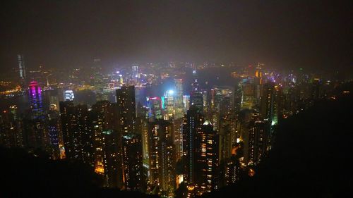 Illuminated cityscape against sky at night