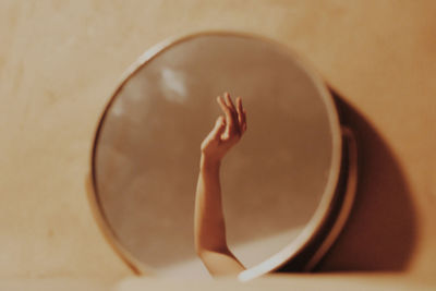 Cropped hand of woman reflecting on mirror