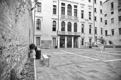 Rear view of people walking on street against buildings