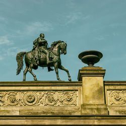 Low angle view of statue on building against sky