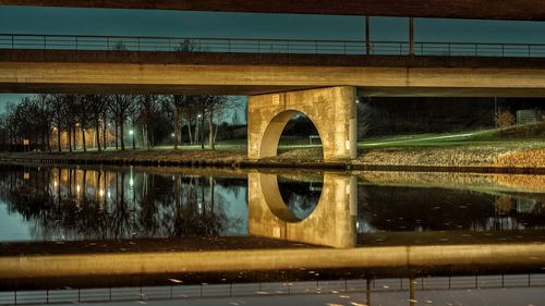 Arch bridge over river against sky