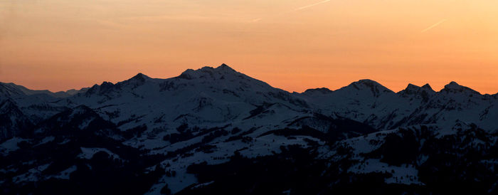 Scenic view of snowcapped mountains against sky during sunset